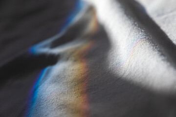 Beam of sunlight with spectrum colors goes over white fabric