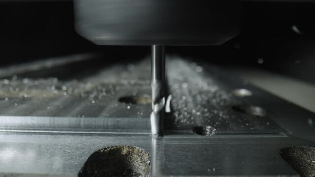 Automatic cnc turning milling machine cutting metal workpiece with shavings at factory. Metalworking, manufacturing concept. Metal workpiece is machined by an electric machine. Slow motion. Close up.