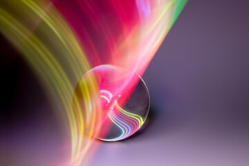 Glass ball and multicolored reflections on gray background