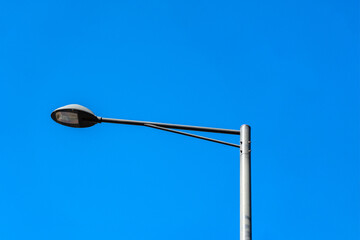 Street lamp installed on the roadside on a clear sky background