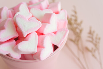 Fluffy pink heart marshmallow in small tank on pink background. Love and dessert concept.