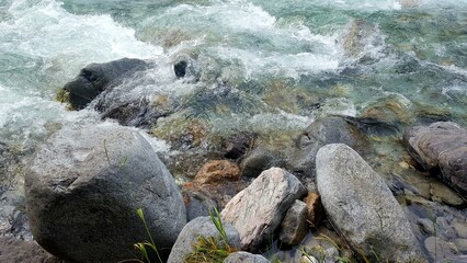 rapid flow of a mountain river between large stones. The beauty of two elements