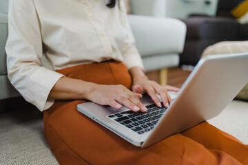 Working by using a laptop computer on wooden table. Hands typing on a keyboard.technology e-commerce concept