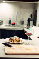 Pasta bolognese with a glass of pinotage red wine. Wine from the Pinotage grape variety. Italian cuisine at home. Dishes of Italian cuisine with your own hands.