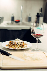 Pasta bolognese with a glass of pinotage red wine. Wine from the Pinotage grape variety. Italian cuisine at home. Dishes of Italian cuisine with your own hands.