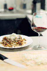 Pasta bolognese with a glass of pinotage red wine. Wine from the Pinotage grape variety. Italian cuisine at home. Dishes of Italian cuisine with your own hands.