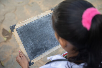 A kid writing the letter in a slate,Top View