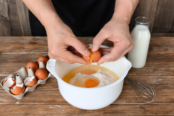 Man prepares dough on dark wooden table