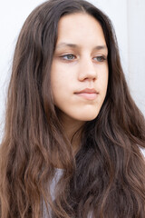 Young attractive girl with grey eyes and dark open hair looking away