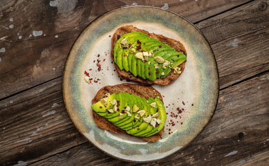 Avocado toast. Healthy toast with avocado for breakfast or lunch with rye bread. Clean eating, dieting, vegan food concept. Food recipe. Long banner format. top view