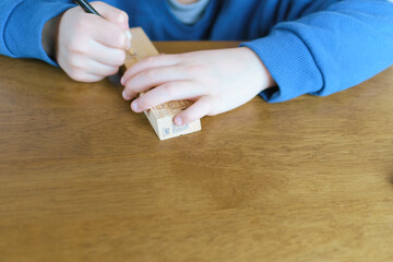 幼児が木材で工作（リモコン）を製作中。色鉛筆。コピースペース