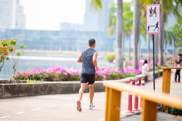 Man is jogging in a park in the city. Active healthy runner jogging outdoor. Running in city park....