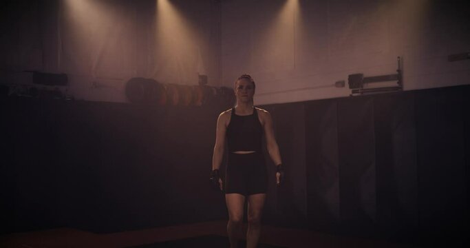 A Slow Motion Portrait Of A Strong Female Boxer In An MMA Gym. Shot In A Crossfit Boxing Gym With Low Key Lighting And A Scattering Of Haze. Captured On Red Digital Cinema Camera 