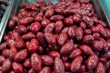 Red olives close up on market, food background