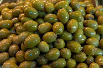 Green fresh olives close up on market, food background