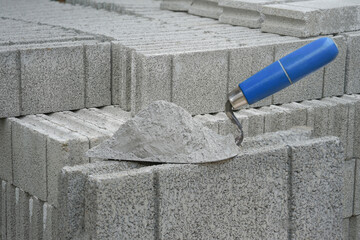 mortar pile on trowel put on a brick block background - obrazy, fototapety, plakaty
