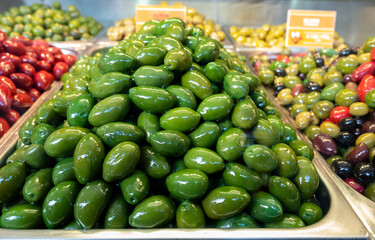 Green fresh olives close up on market, food background