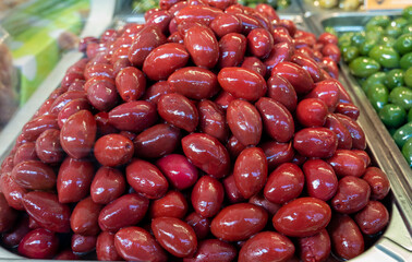 Red olives close up on market, food background