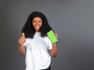 young black african youth holding a mobile phone and look at the camera