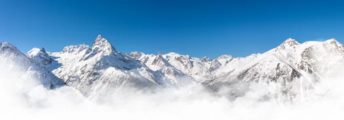 Fotobehang Panoramic view of winter snowy mountains in Caucasus region in Russia with blue sky © SDF_QWE