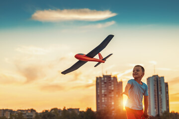 Little boy playing with toy airplane in the city