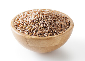 Grains of spelt in wooden bowl isolated on white background wiht clipping path