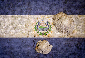 Stone wall with the flag of El Salvador and Bullet holes