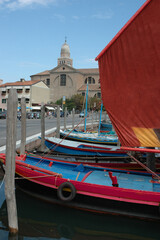 Fototapeta na wymiar Chioggia. Venezia. Barca da regata con vela davanti alla Cattedrale di Santa Maria Assunta.