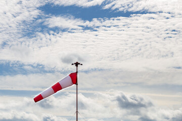 Windsock with cloudy sky in the background.