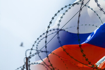 Flag of Russia on the background of barbed wire. Martial law in Ukraine. Stop war