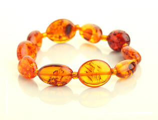 bracelet of pieces of brown amber on reflecting surface