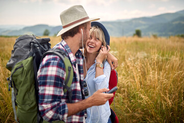 Close-up of a young happy couple in love who is in a hug while enjoys walking a meadow. Hiking, nature, relationship, together