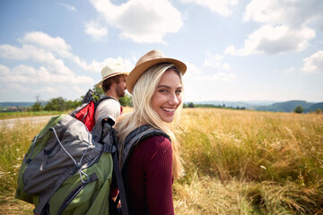 Hiker woman smilling and walking in field with a man, nature outdoor. Sport, freedom, holiday...