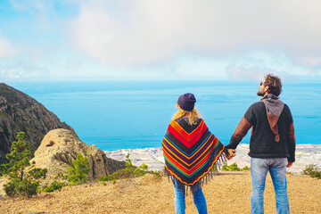Tourist couple holding hands and admiring nature around. People in love standing and looking...