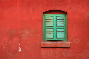 Abstract image of an old green window on grungy red wall - Powered by Adobe