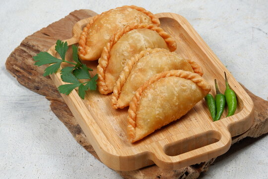 Curry puff or Pastel Goreng is Pastry Popular in Indonesia.
fried pastry with filling of sautéed vegetable , chicken and boiled egg. accompanied with  sauce or raw chilli pepper