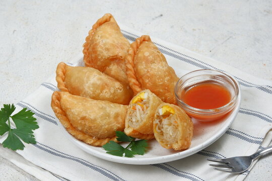 Curry puff or Pastel Goreng is Pastry Popular in Indonesia.
fried pastry with filling of sautéed vegetable , chicken and boiled egg. accompanied with  sauce or raw chilli pepper