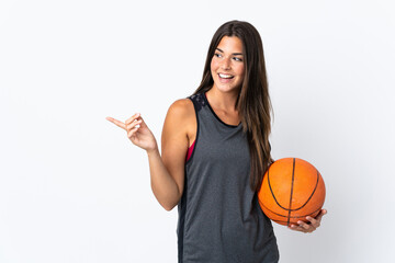 Young brazilian woman playing basketball isolated on white background pointing finger to the side...