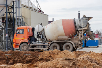 Concrete mixer truck loads concrete at the factory. Transportation of concrete to the construction site. Construction equipment for the delivery of concrete.