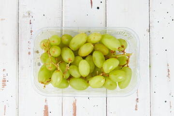 A box seedless green grapes packed in a transparent plastic box