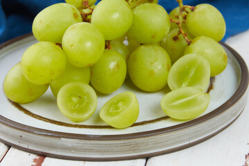 Bunches of fresh ripe green grapes on a wooden table