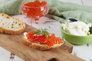 Red caviar on a wooden table, bruschetta with caviar