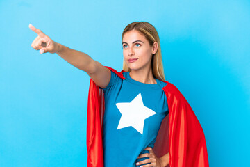 Blonde woman over isolated background in superhero costume with proud gesture