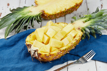 Ripe and juicy pineapple on a white wooden table, pineapple half, slices, close-up
