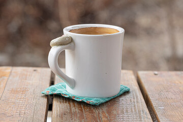 Homemade mug cup and coffee on wooden background.
