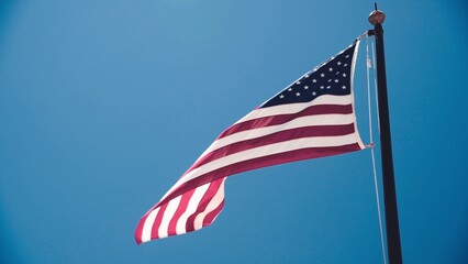 Beautiful american flag against the blue sky Slow motion