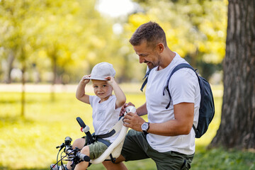 Fototapeta premium A father and son preparing to ride a bike in nature on earth's day.