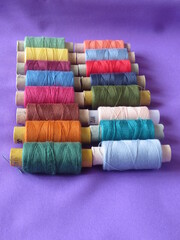 Multicolored threads for sewing. Spools of thread of different colors are stacked in a row.