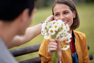 Man giving bouquet of flowers to a woman; Happy couple concept