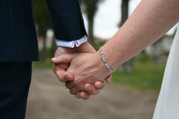 Les mariés qui se tiennent la main pendant leur mariage